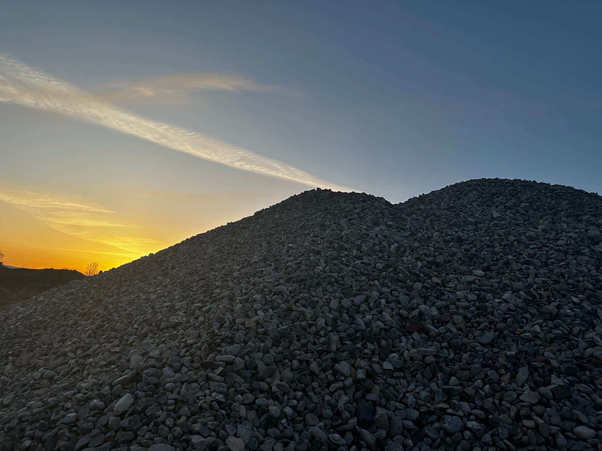 Darby Pit, Gravel & Trucking - We specialize in providing top-quality materials such as dirt, sand, gravel, and crushed stone, perfect for all your excavation and landscaping needs. Our range of services caters to home builders and developers focused on constructing roads, paths, driveways, and foundations. With our reliable trucking services for transportation and delivery, we ensure your project’s success from start to finish. Picture this: silhouettes of gravel mounds bathed in the golden hues of a twilight sunset—a testament to the raw beauty and utility of our materials in shaping your vision.