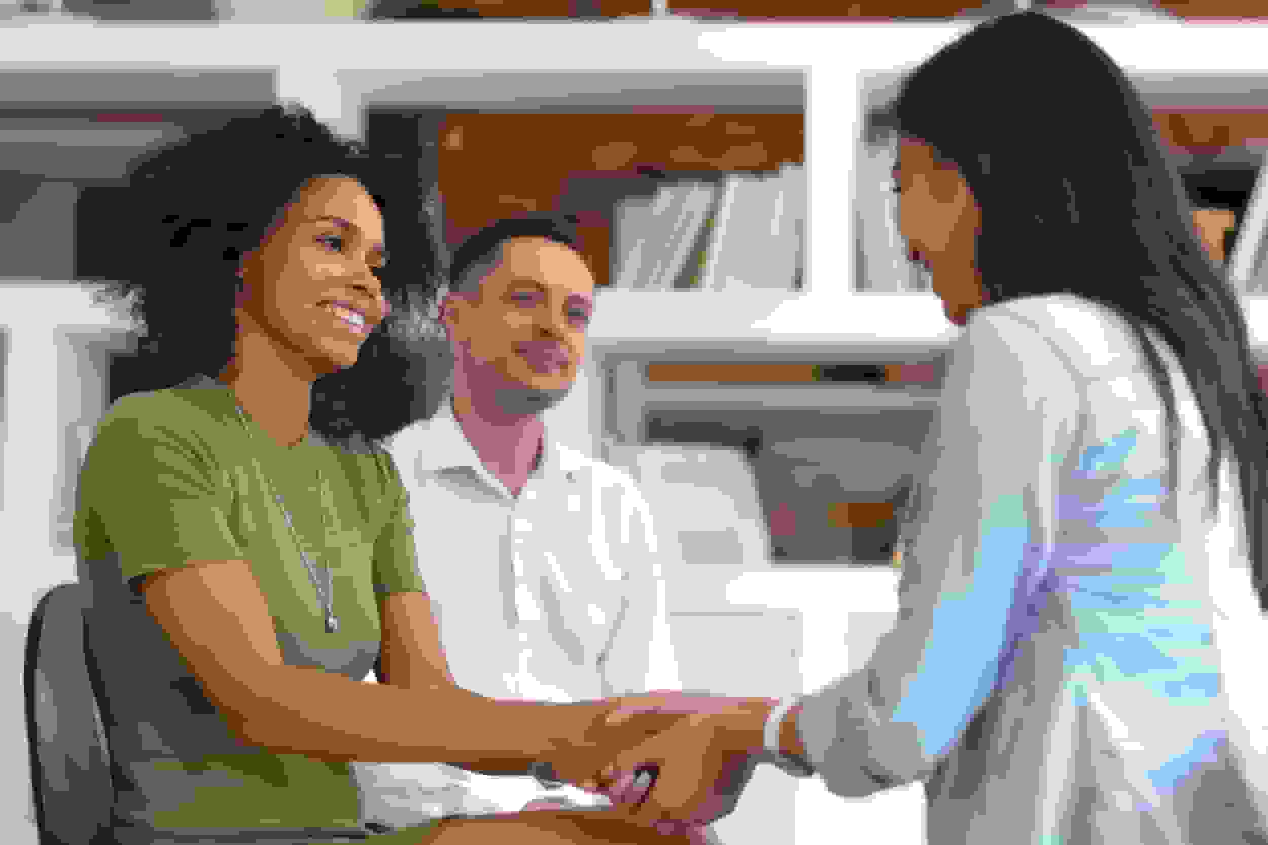 Asian and african women holding hands during group therapy session