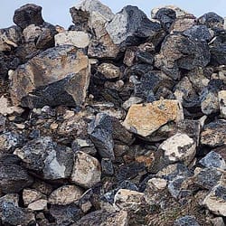 Darby Pit, Gravel & Trucking - We specialize in providing top-quality materials, including dirt, sand, gravel, and crushed stone. Whether you need these essential aggregates for excavation projects, landscaping enhancements, home building ventures, road construction, path creation, driveway installation or laying a solid foundation—we've got you covered. 

Additionally, our comprehensive trucking services ensure your materials are delivered right where you need them efficiently and on time.

Picture this: a substantial pile of Riprap made up of large jagged rocks primarily in shades of gray and white silhouetted against a clear blue sky—a testament to the quality and durability we offer.