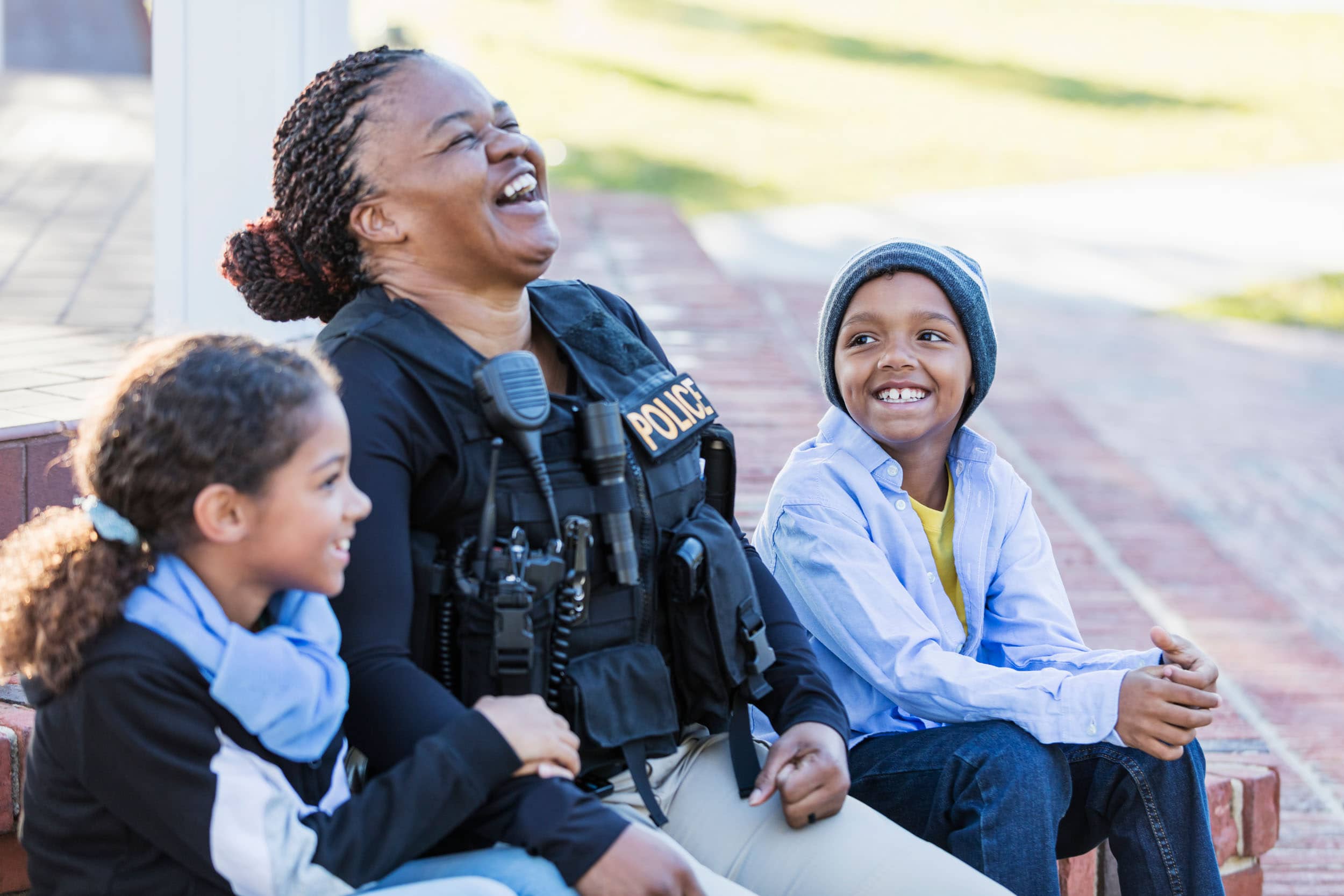 Policewoman In The Community, Sitting With Two Children