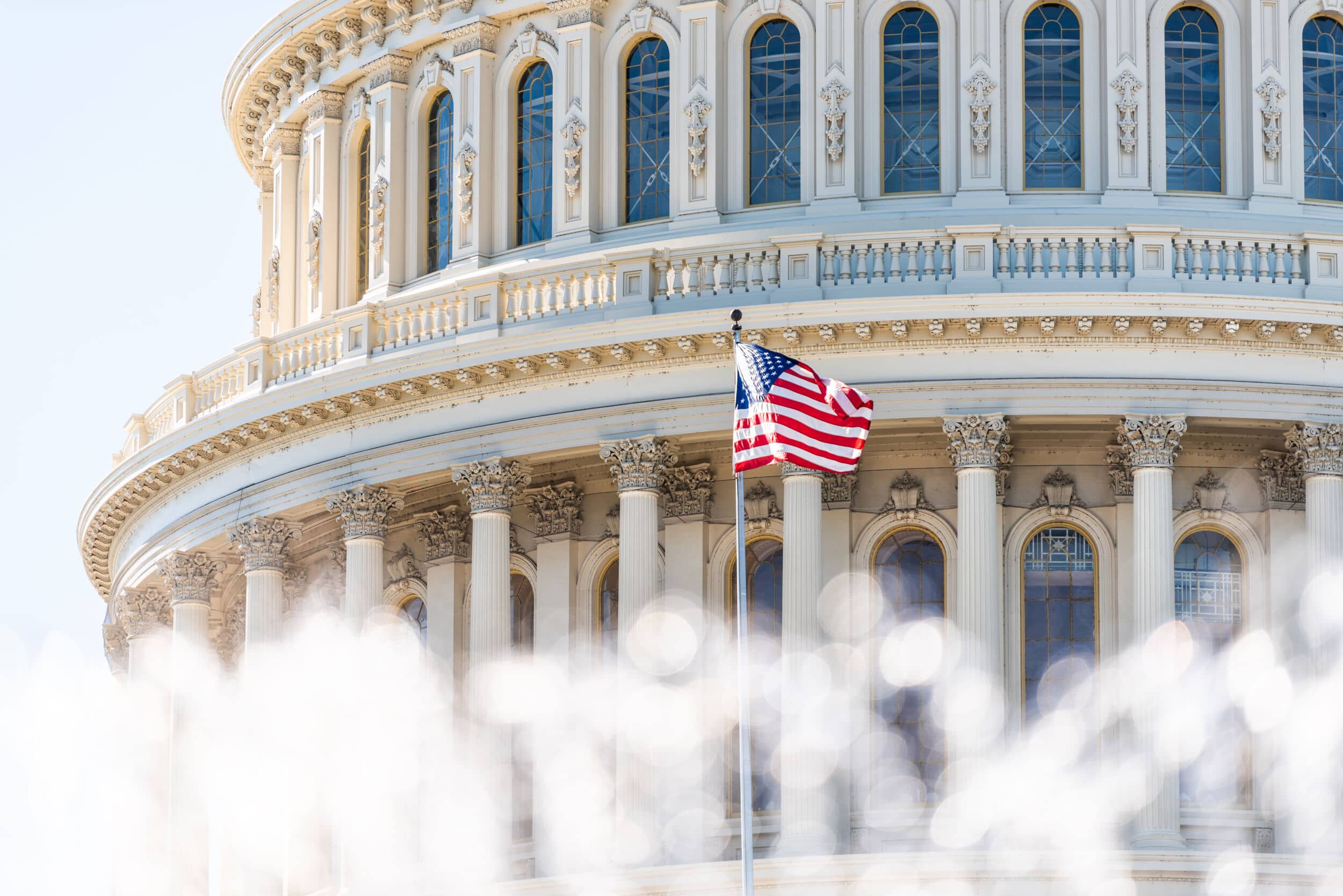 Us Congress Dome Closeup With Background Of Water Fountain Splashing, American Flag Waving In Washington Dc, Usa Closeup On Capital Capitol Hill, Columns, Pillars, Nobody