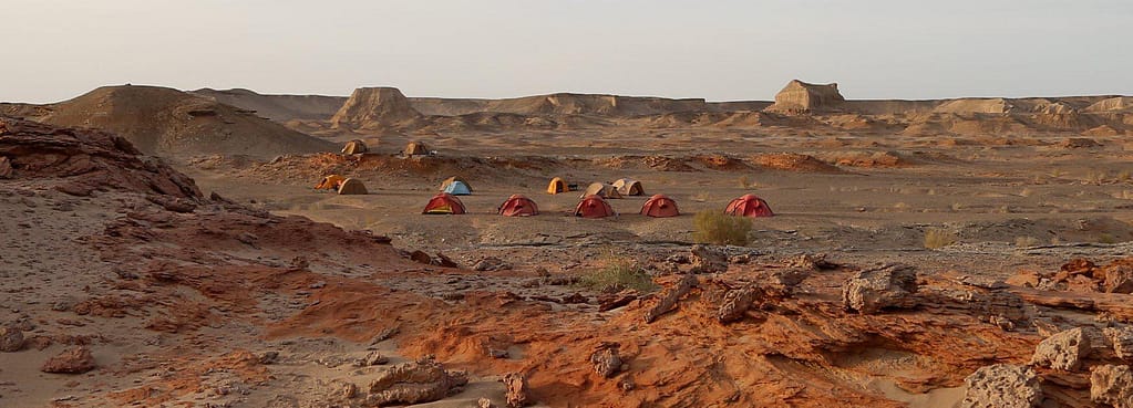 Expedition tents on red desert ground in the Gobi