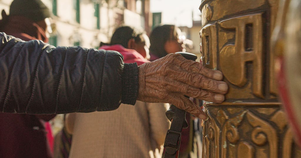 Hand turning prayer wheels at a temple