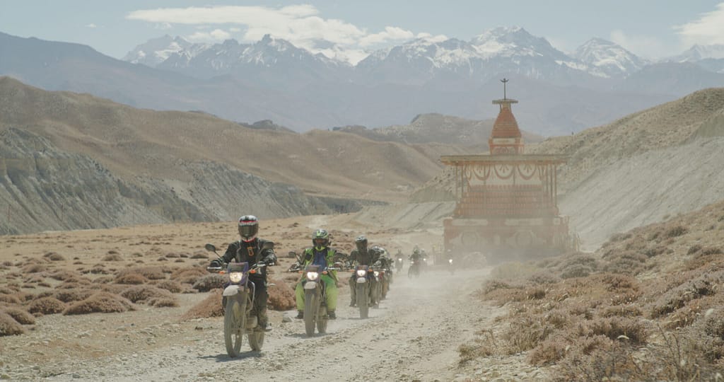 Adventure motorcycles parked beside a stupa on a Himalayan dirt road