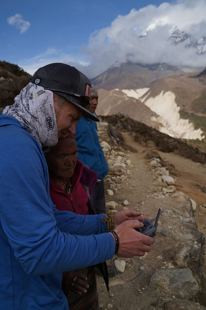 Camera operator filming an interview in the mountains